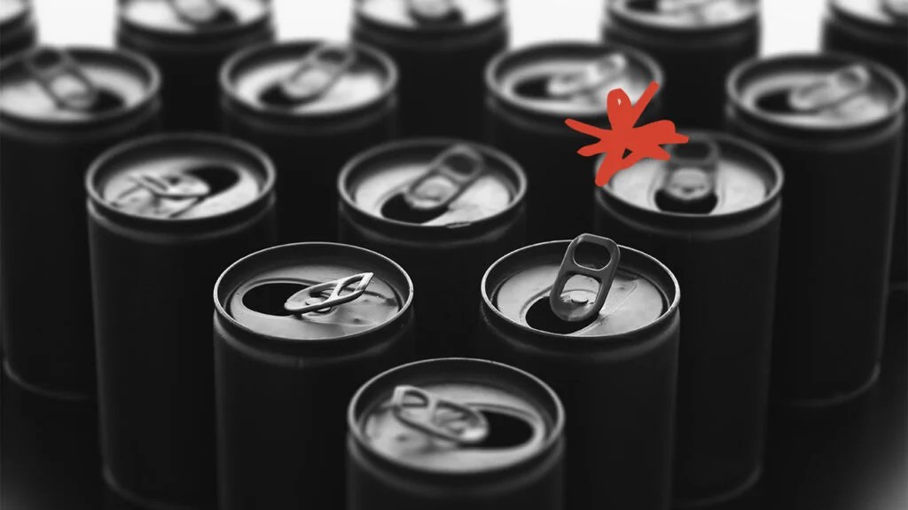 black and white photo of opened soft drink cans